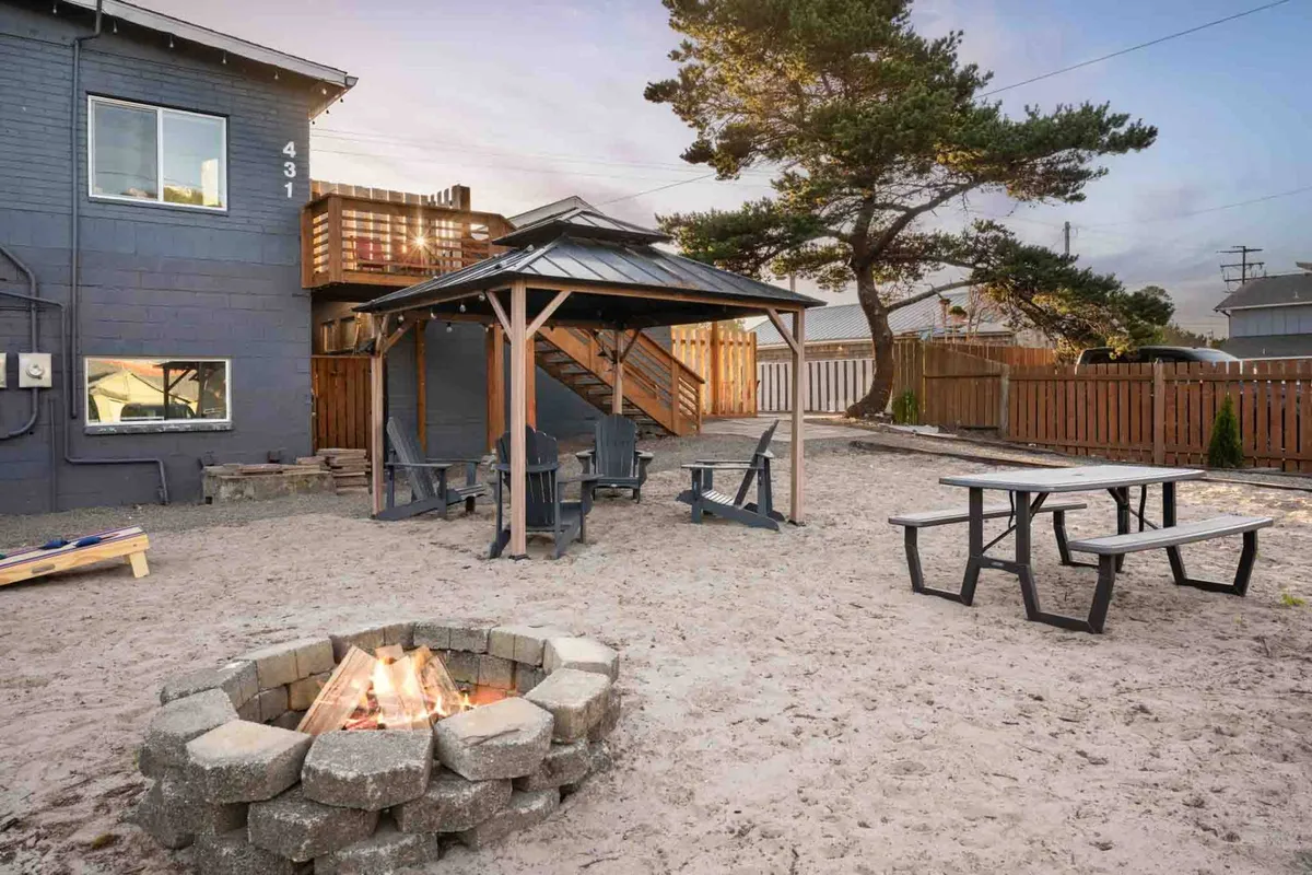 An inviting communal outdoor space featuring a fire pit, gazebo, and comfortable outdoor seating, set against the backdrop of the cottages. The setup is ideal for socializing after a day of exploration—whether gathering for s'mores around the fire or relaxing in the gazebo with friends.